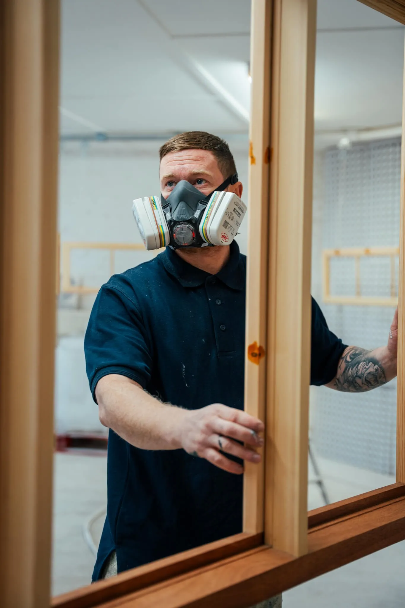 Pelham Joinery worker in mask hanging a finished window frame ready for painting