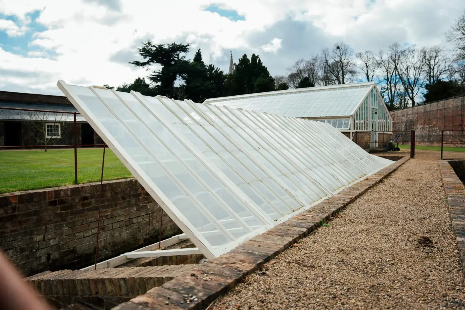 Recessed greenhouse with hinged glass panels manufactured by Pelham Joinery