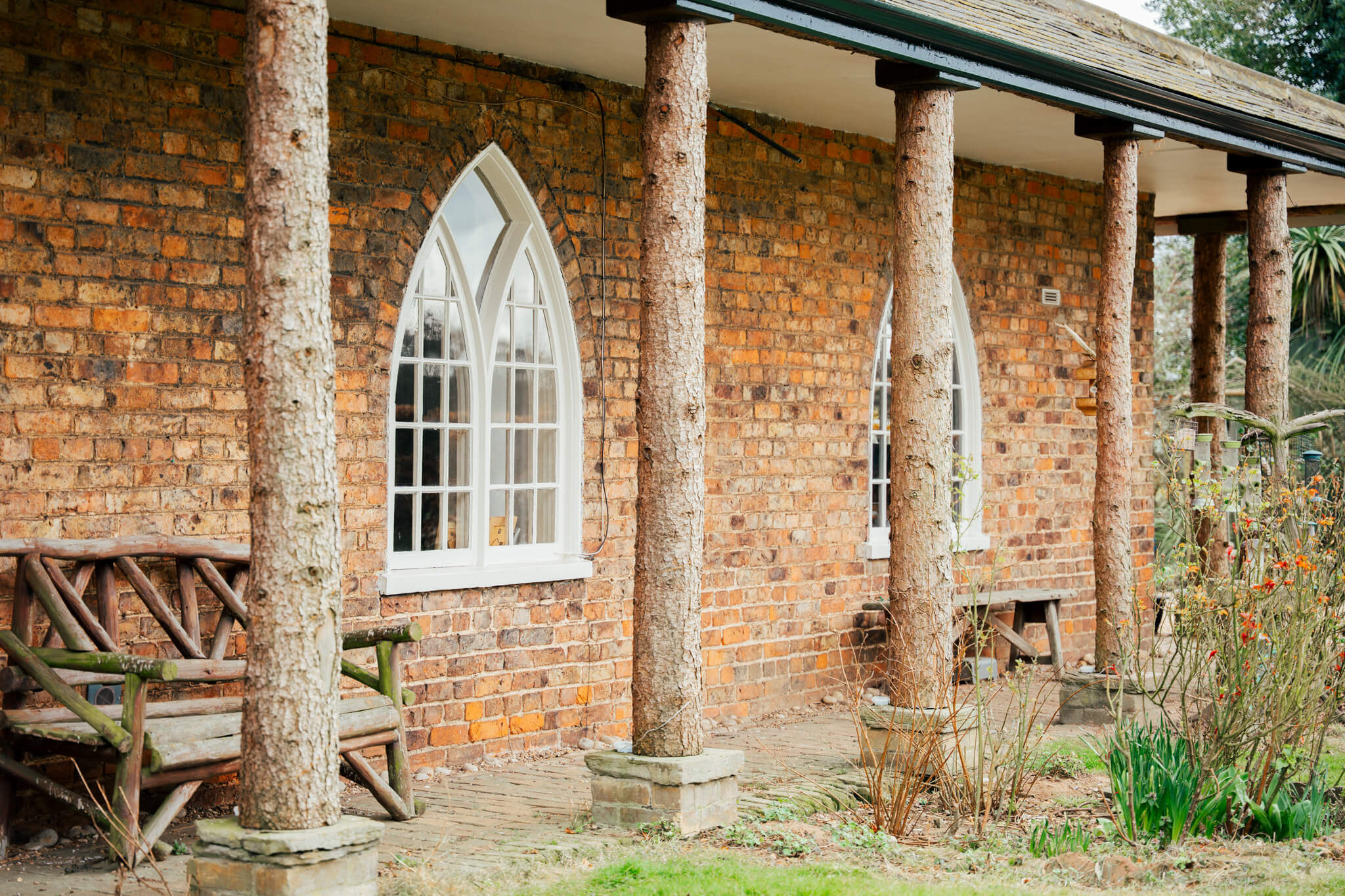 Tilt and turn arch windows at Brockelsby Lincolnshire with rustic bench and garden and live edge wooden pillars