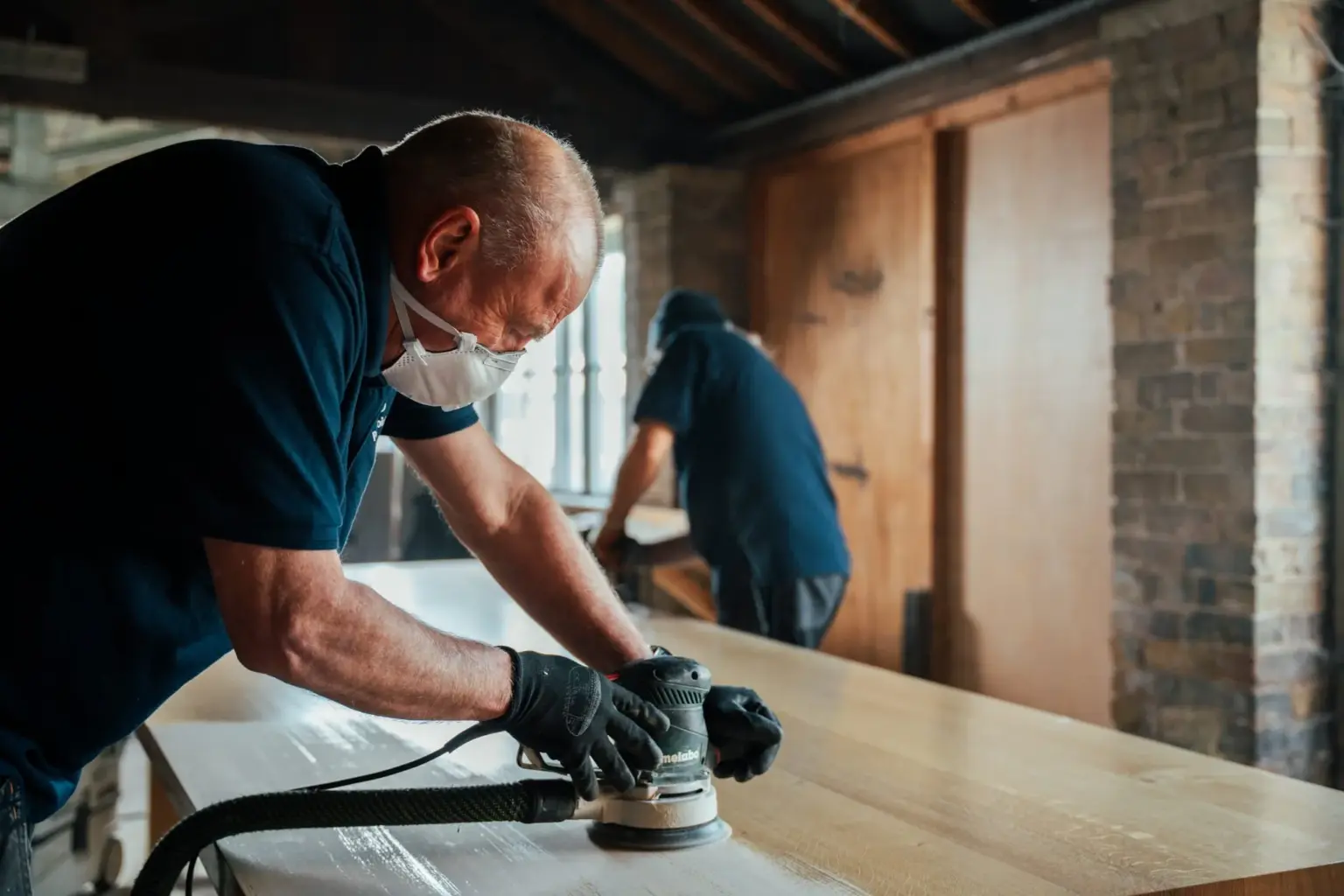 Joiner sanding a table